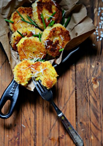 saffron risotto cakes inside black skillet with fork in one cake