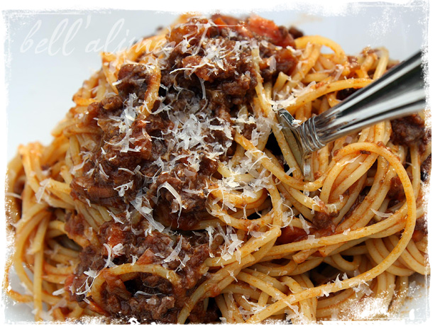 Close up of spaghetti with meat sauce and cheese. Fork in pasta. 