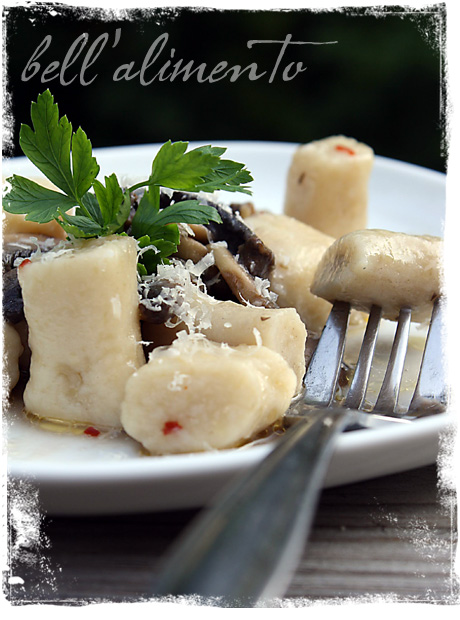 plate of Gnocchi with Mushroom Sauce. Fork in one piece of gnocchi.