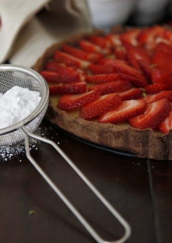 strawberry tart, sieve with powdered sugar to side.