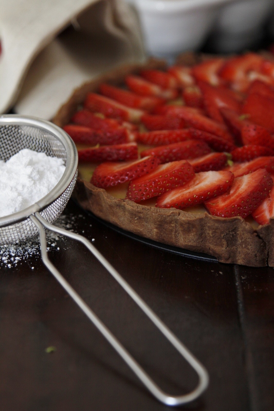 strawberry tart, sieve with powdered sugar to side.