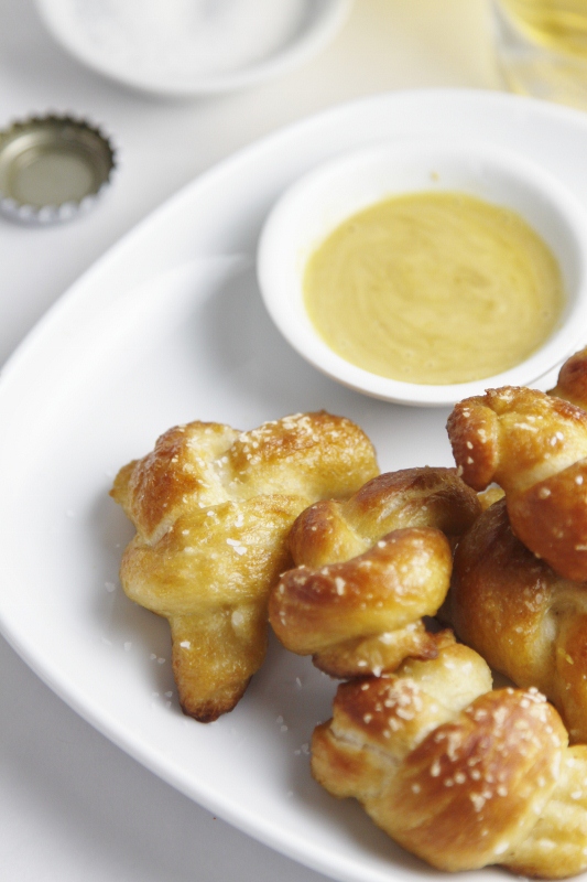 pretzel bites on white plate with mustard dipping sauce in small bowl.