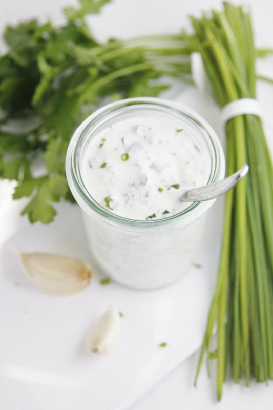 ranch dressing in small glass jar with ingredients to side.