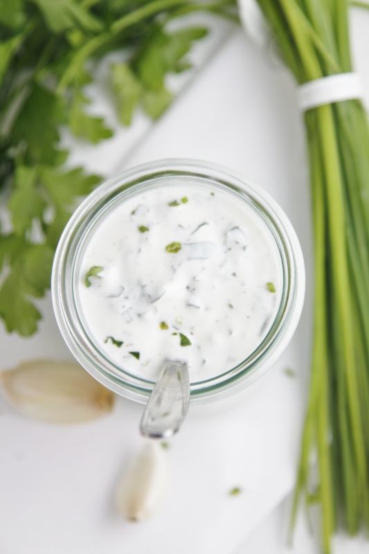 small glass jar of homemade ranch dressing with spoon.