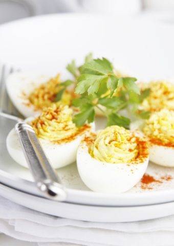 Classic Deviled Eggs on white plate garnished with parsley