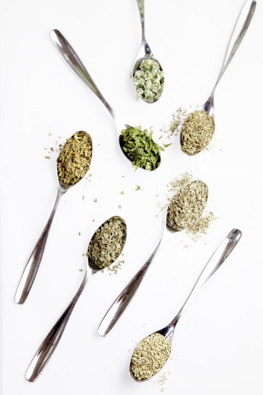 7 small spoons with a different dried herb in each spoon. 
