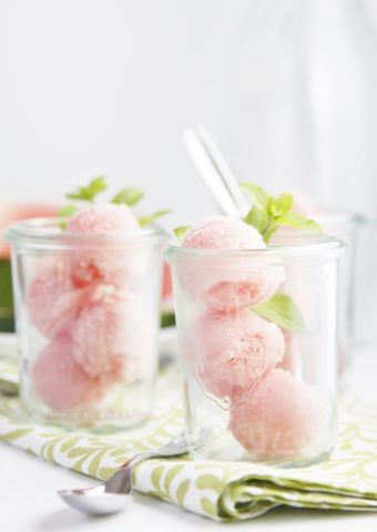 small glass jars with scoops of watermelon sorbet and fresh mint
