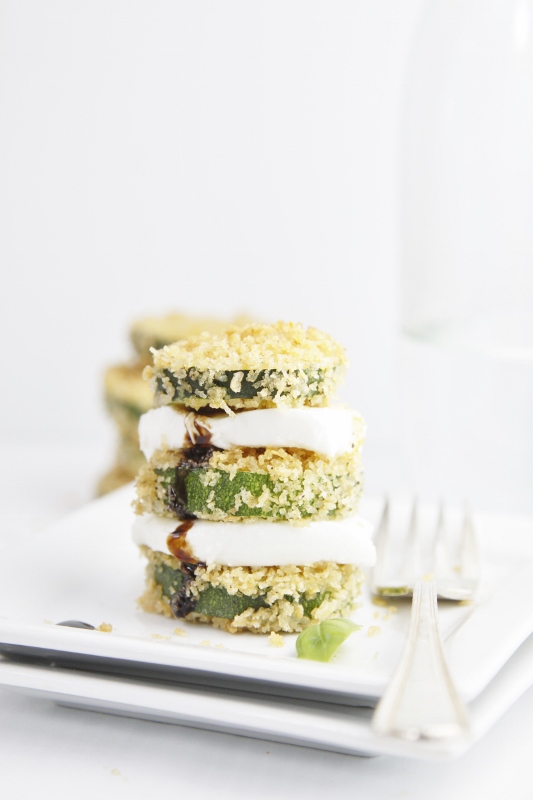Baked Zucchini Stacks with mozzarella on white plate with fork.