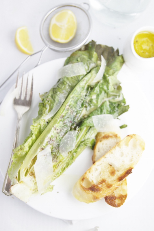 grilled Caesar salad on white plate with fork.