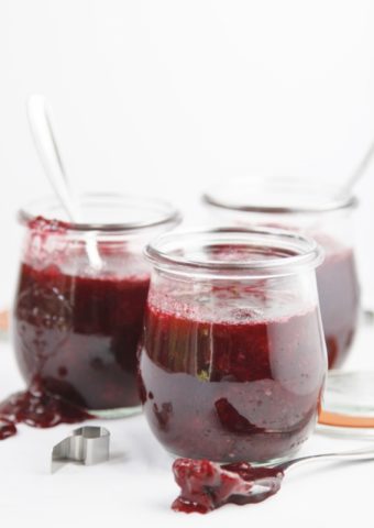 three small glass jars of berry jam.