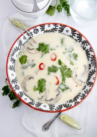 decorative bowl of thai coconut soup with ladle handle sticking out.