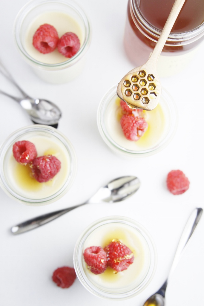 Chai Panna Cotta in small glass jars with raspberries.