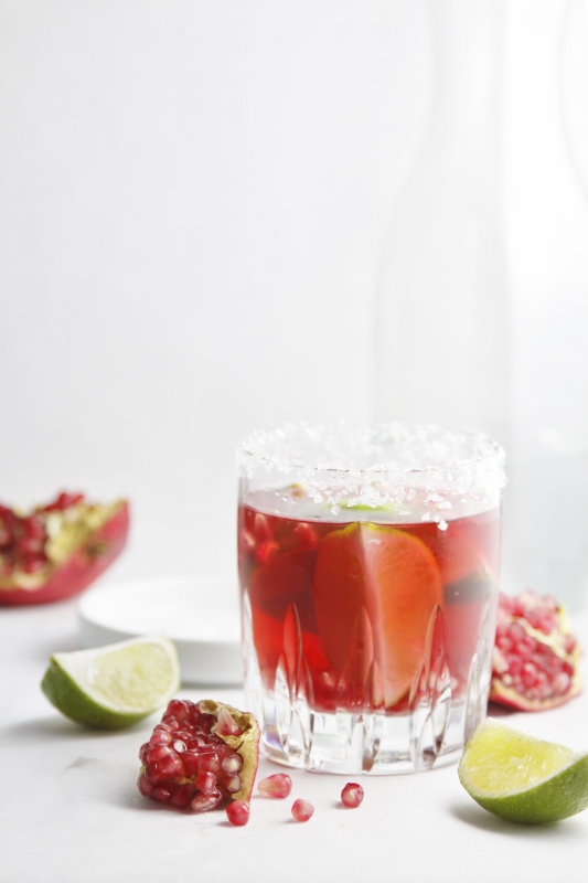 Pomegranate Lime Margarita with lime wedges scattered around.