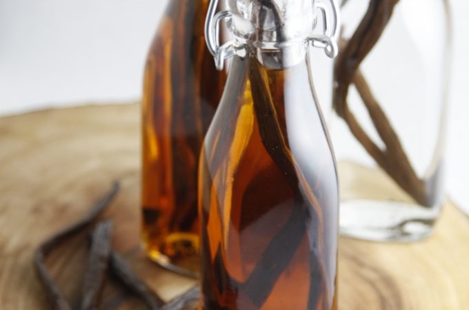 DIY Vanilla Extract in glass jars with vanilla beans to side