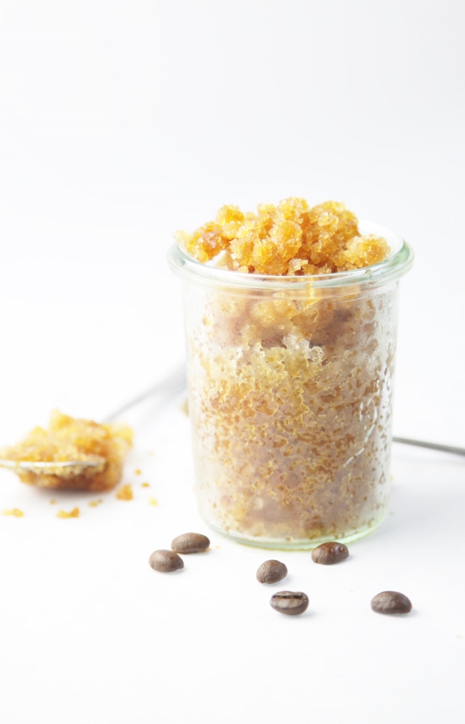 glass jar of coffee granita. Spoon full of granita and scattered coffee beans to side.