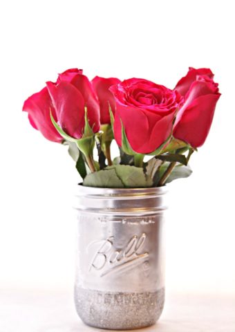 silver painted mason jar with glitter rim and red roses.