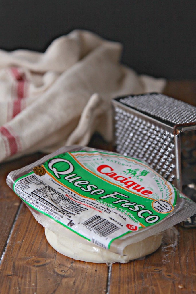 Cacique Queso Fresco, cheese grater and kitchen towel to side. 