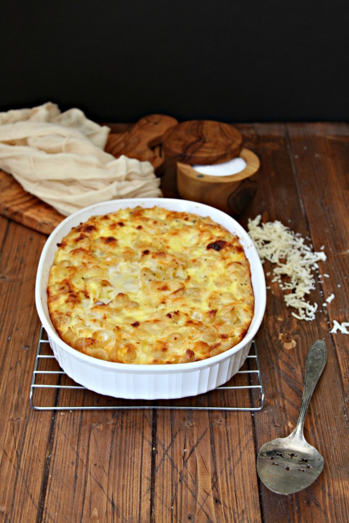 Baked Macaroni and Cheese in white dish sitting on cooling rack. Salt cellar in background. 