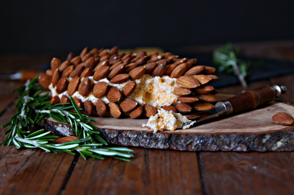 Pine Cone Shaped Holiday Cheese Ball, cheese spreader with dollop of cheese to side. 