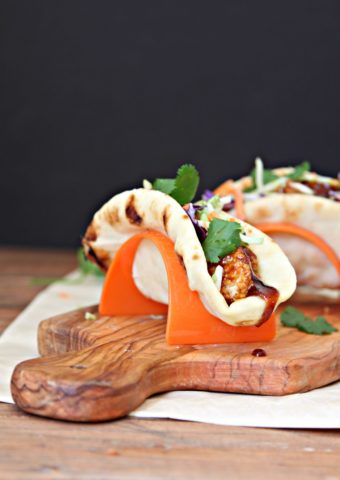BBQ Chicken Naan Tacos in taco stands on cutting board.