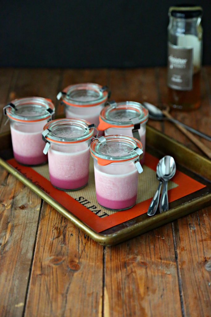 jars of beet panna cotta on a baking tray with spoons