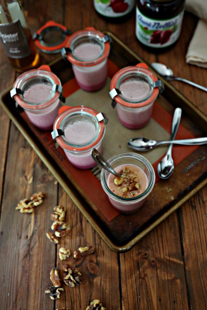 jars of beet panna cotta on baking tray with silver spoons 