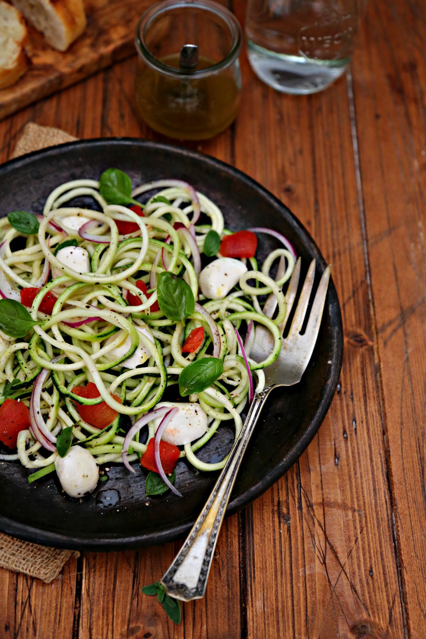 zucchini noodle salad on brown plate with silver serving fork