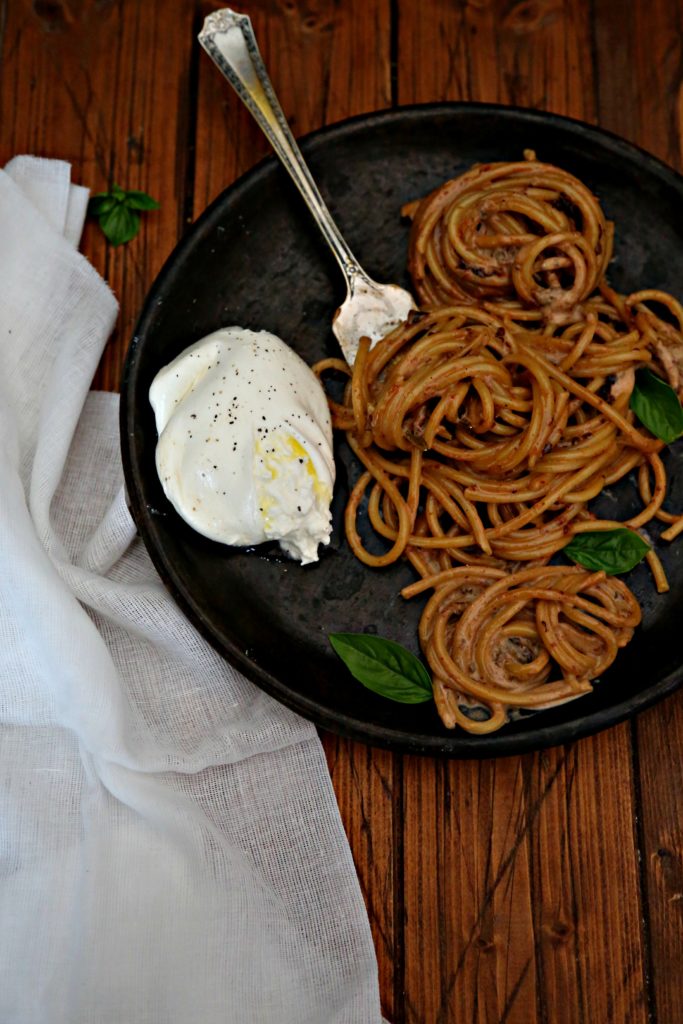 4 ingredient Bucatini with Creamy Sun Dried Tomato Sauce on brown plate with fork and burrata 