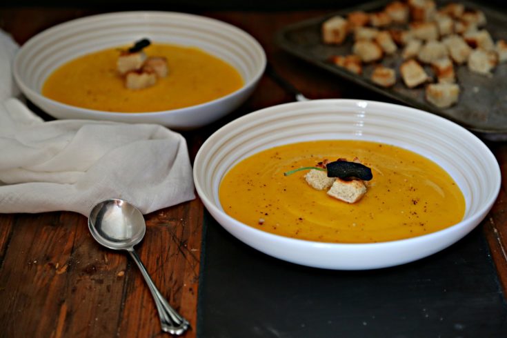2 bowls of Roasted Butternut Squash Soup with spoons and a tray of toasted croutons