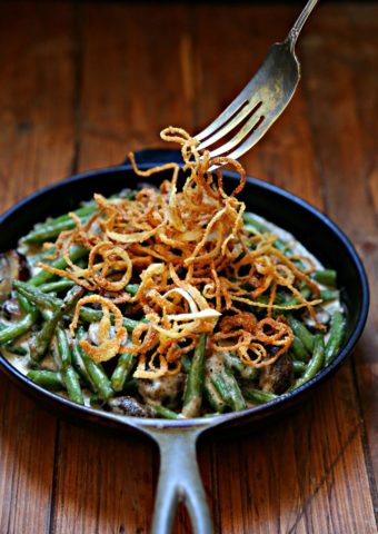 Fresh Green Bean Casserole in a skillet with Crispy Onions being pulled with fork