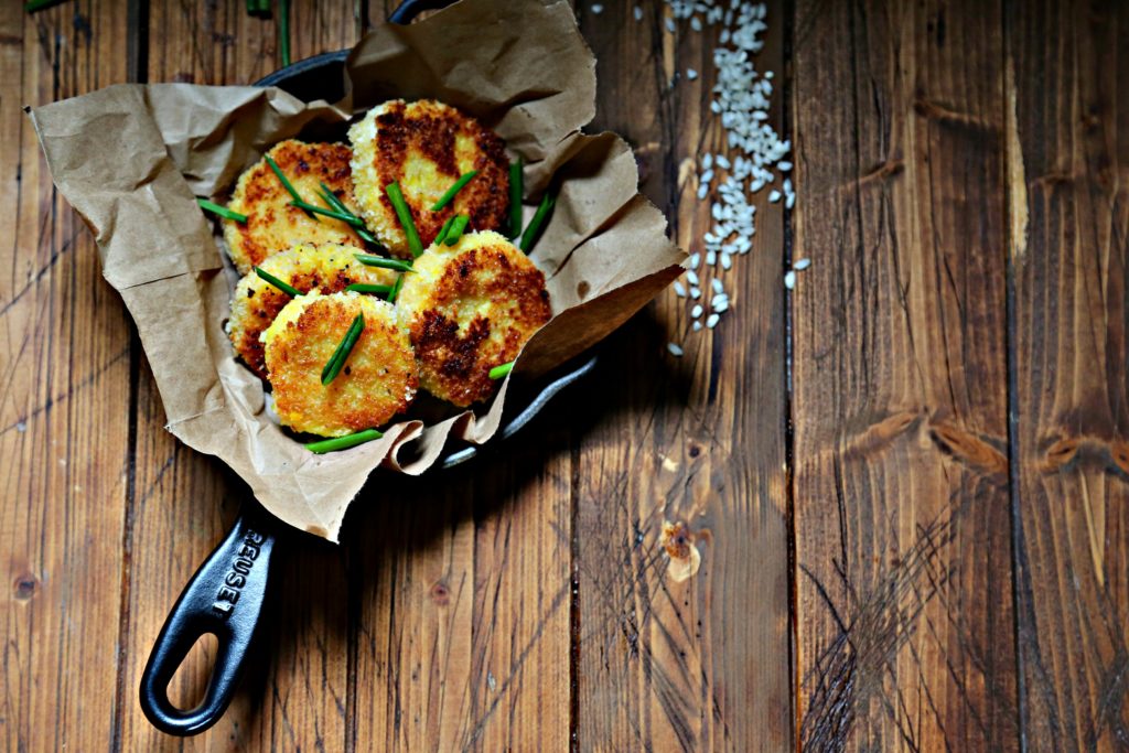 Saffron Risotto Cakes in skillet with risotto scattered to side 