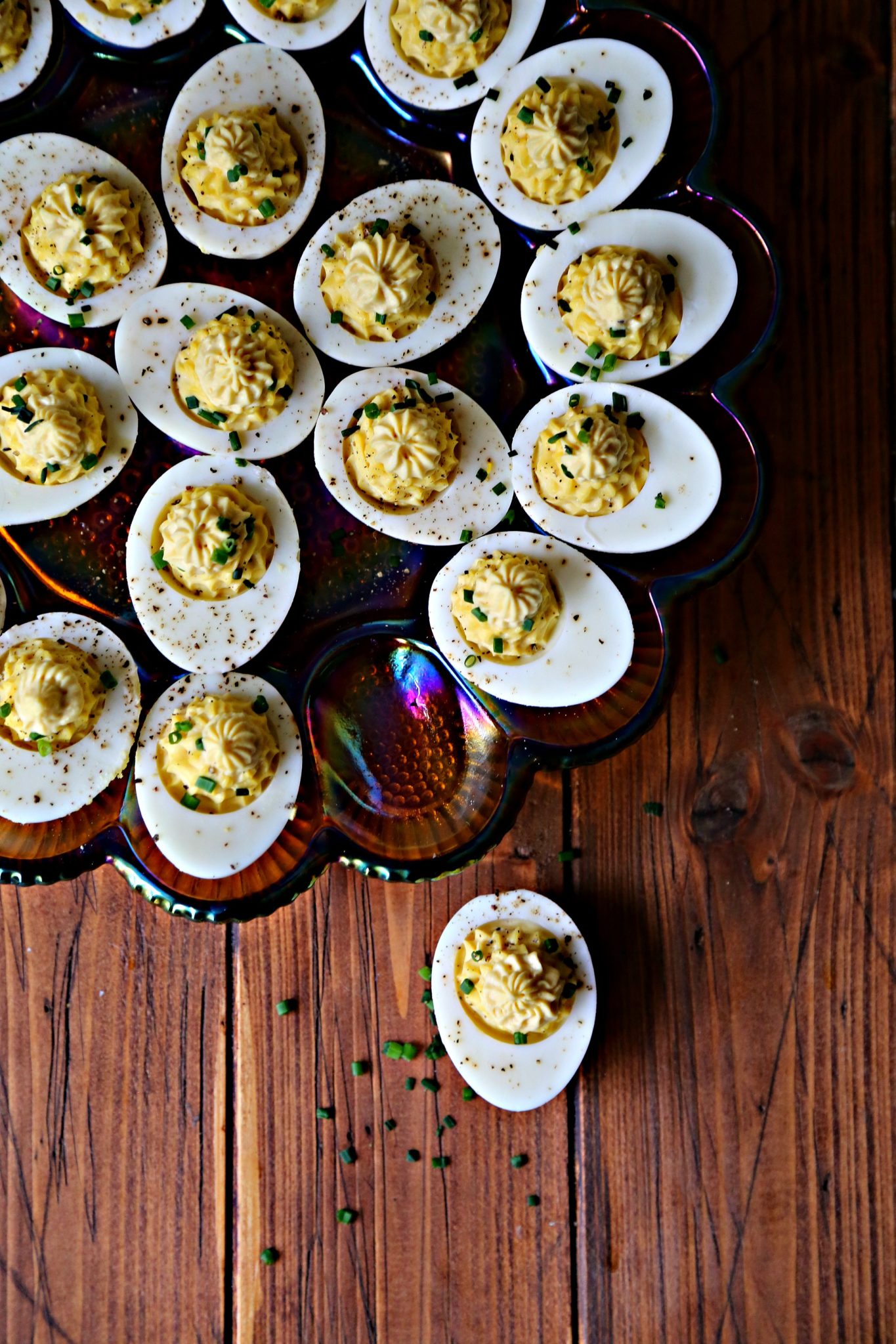 Deviled eggs on depression glass deviled egg plate. One egg in front. These classic Southern style Maille Deviled Eggs are the perfect appetizer or side dish to serve for your Easter brunch!