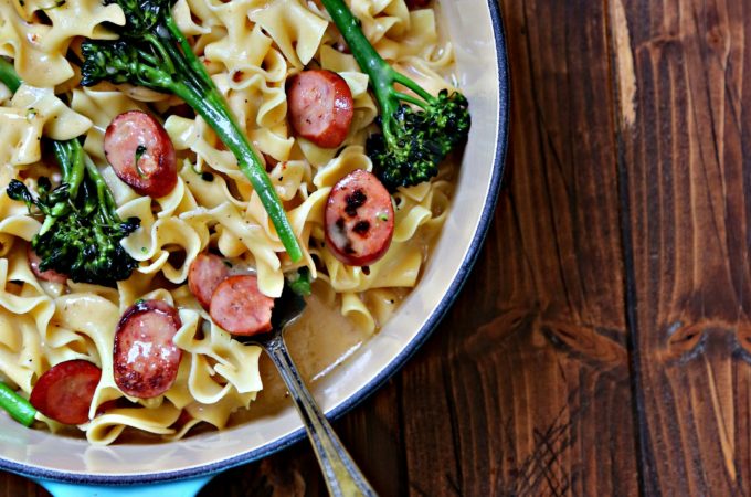 Pasta with sausage and broccoli in blue pan.