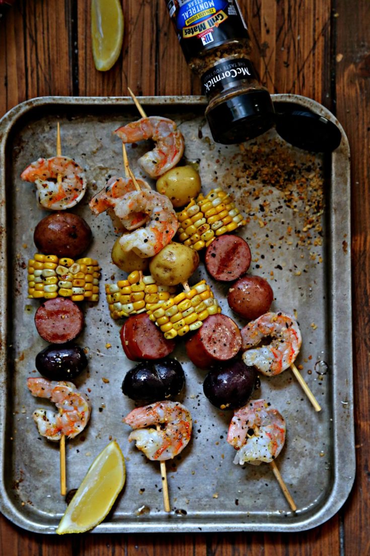 low country boil kebabs on baking sheet with spice jar.