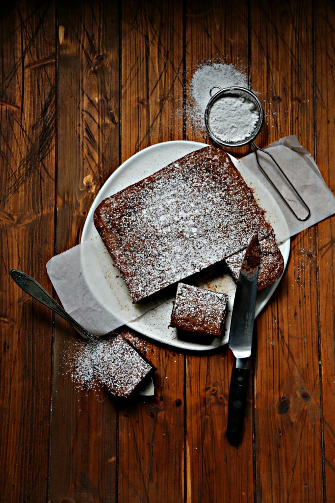 chocolate brownies on white plate with knife.
