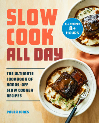 cookbook cover. Text reads slow cook all day the ultimate cookbook of hands off slow cooked recipes paula jones. Bowl of mashed potatoes with short rib and gravy with fork. Additional bowl of mashed potatoes and short rib in background.