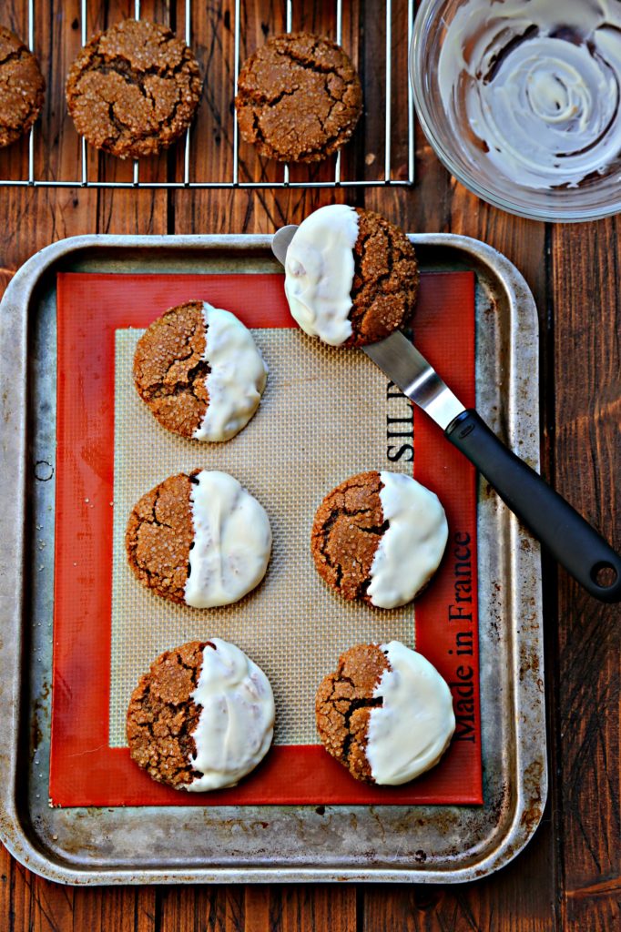 cookies dipped in white chocolate on baking sheet.