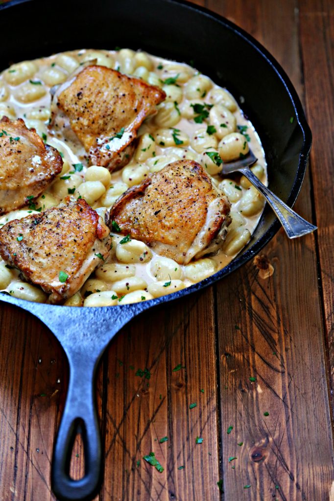 cast iron skillet with chicken thighs and gnocchi.