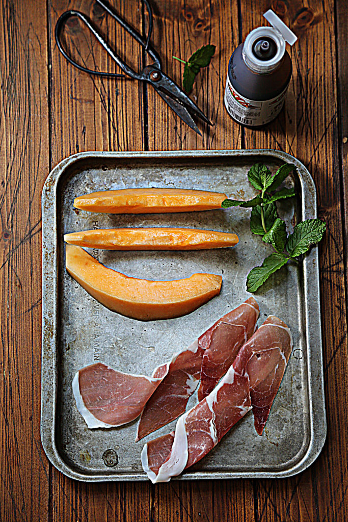 baking sheet with cantaloupe slices, prosciutto, fresh mint. 