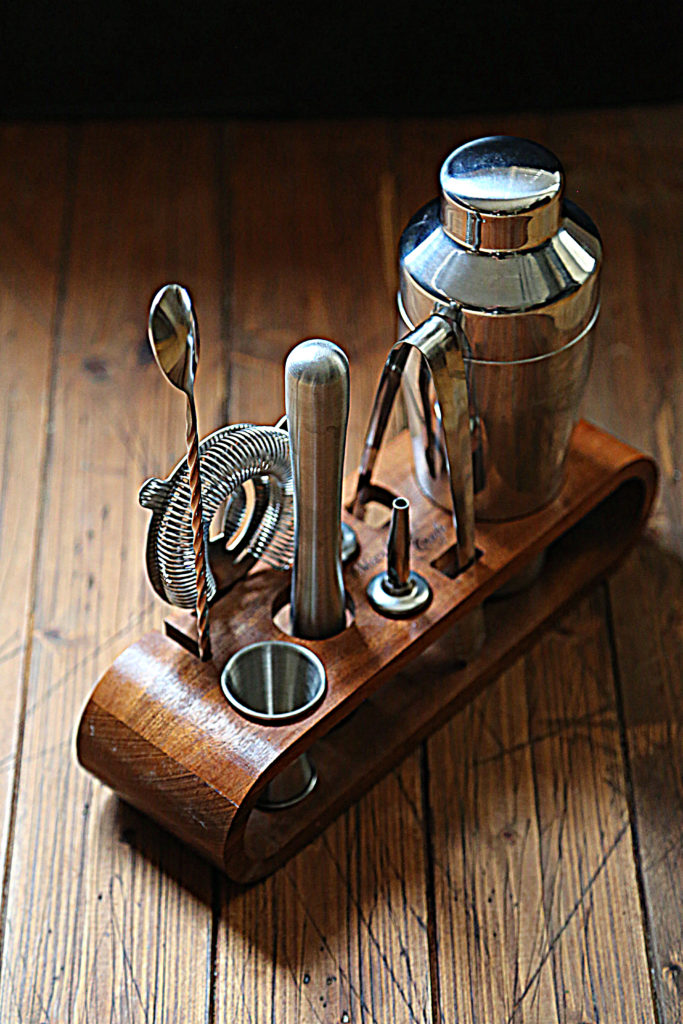 wooden holder with various bar tools. 