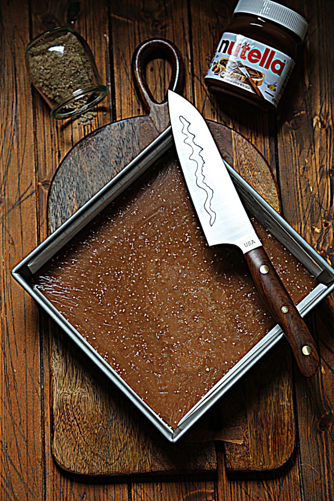 square baking pan of caramels. Knife resting on corner of pan.
