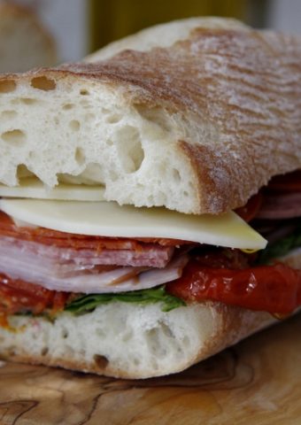half of Italian sub sandwich on cutting board.